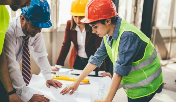 Construction people standing around a construction map